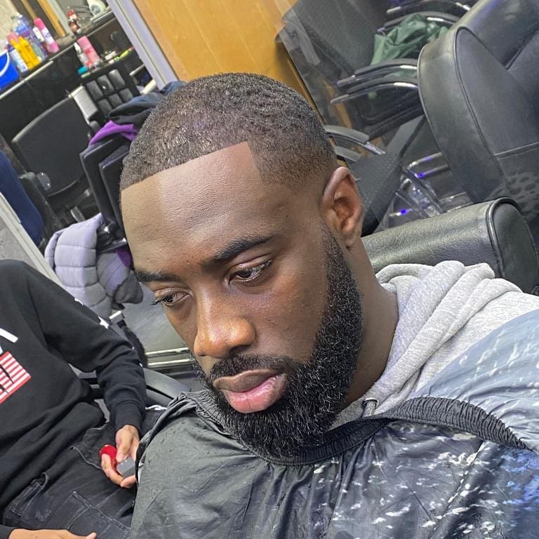 Barber setting the clipper guard for a skin fade